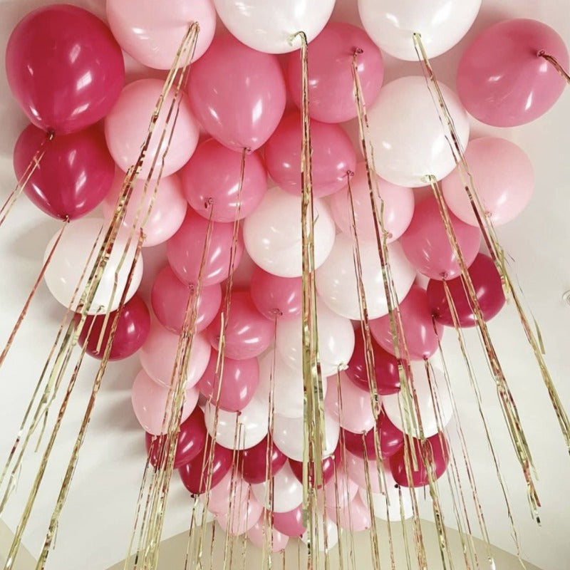 Ceiling balloons in pink tones with foil ribbons inflated with helium